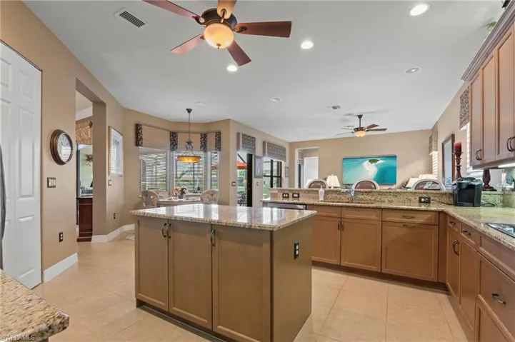 Kitchen with ceiling fan, kitchen peninsula, and light tile floors