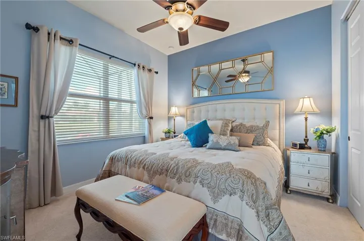 Bedroom with light carpet, a closet, and ceiling fan
