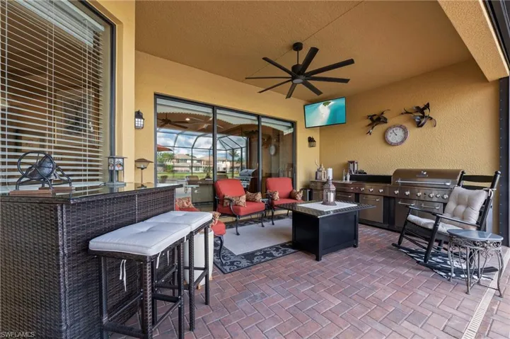 View of terrace with ceiling fan and an outdoor kitchen