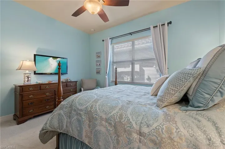 Carpeted bedroom featuring ceiling fan