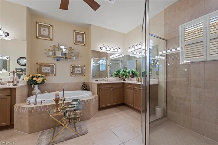 Primary Bathroom featuring shower with separate bathtub, tile flooring, vanity, and ceiling fan