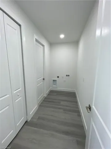 Laundry room featuring electric dryer hookup, wood finished floors, hookup for a washing machine, and recessed lighting