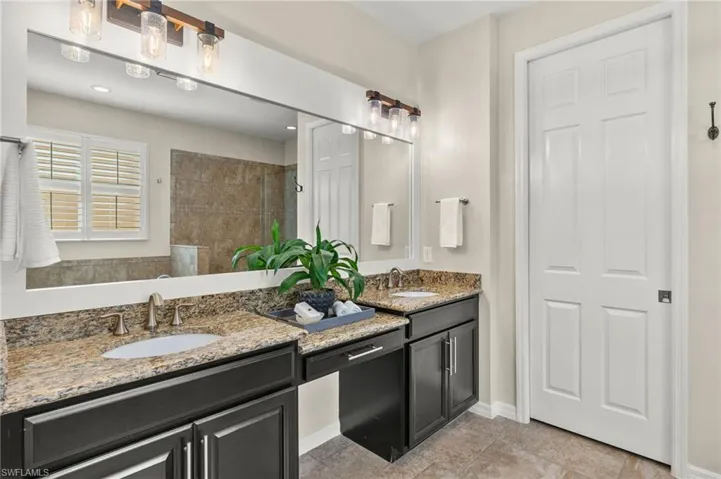 Bathroom featuring a tile shower and vanity