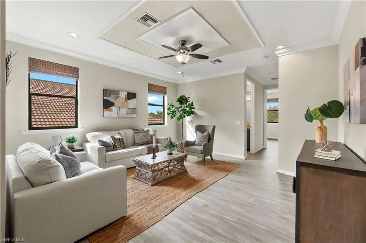 Living room featuring ceiling fan, light hardwood / wood-style flooring, and ornamental molding