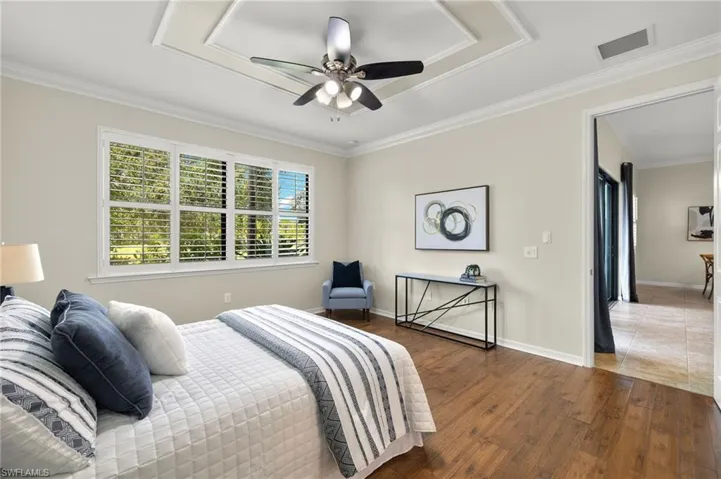 Bedroom with wood-type flooring, crown molding, and ceiling fan