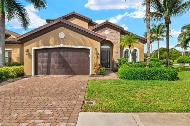 Mediterranean / spanish-style home with a front yard and a garage