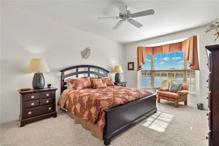 Bedroom with ceiling fan and light colored carpet