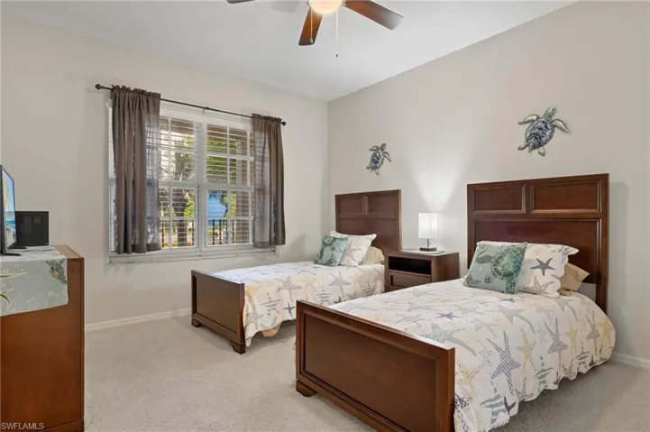 Carpeted bedroom featuring ceiling fan