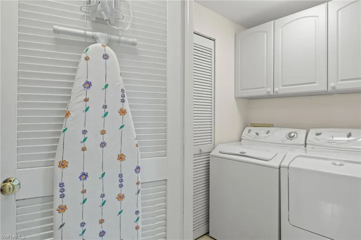 Laundry area with washing machine and clothes dryer and cabinets