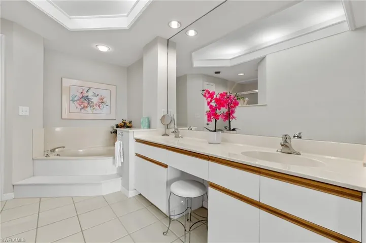 Bathroom featuring large vanity, tile flooring, double sink, and a bathing tub