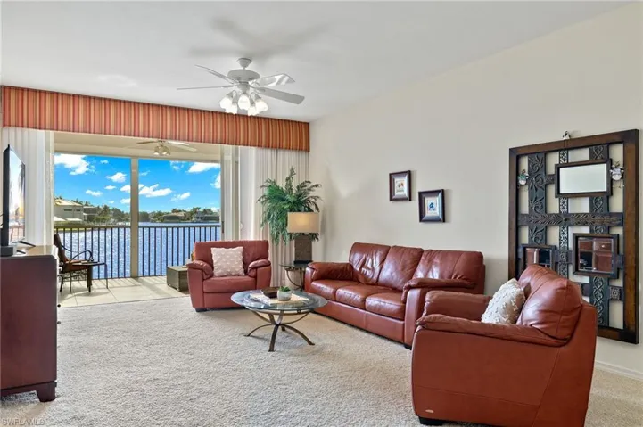 Living room with carpet flooring and ceiling fan