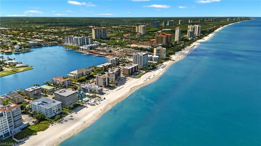 Birds eye view of property with a beach view and a water view