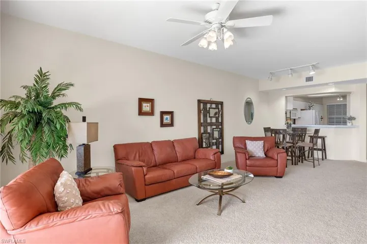 Living room featuring carpet flooring, ceiling fan, and rail lighting