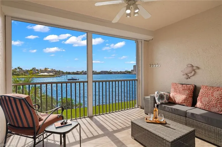 Sunroom / solarium with ceiling fan and a water view