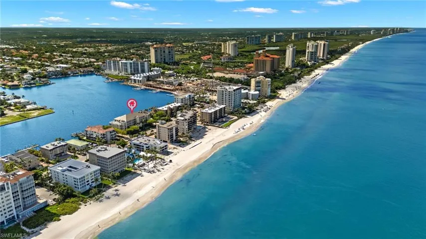 Birds eye view of property featuring a view of the beach and a water view