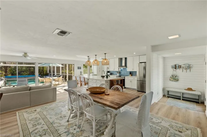 Dining space featuring light wood-style flooring, a sunroom, and ceiling fan