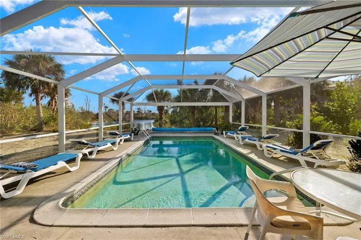 Outdoor pool featuring a lanai, a sunroom, and a patio