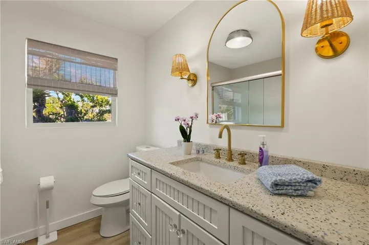 Full bath featuring a stall shower, vanity, and light wood-type flooring