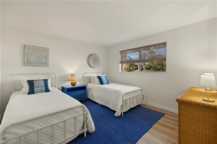 Bedroom with wood finished floors and baseboards