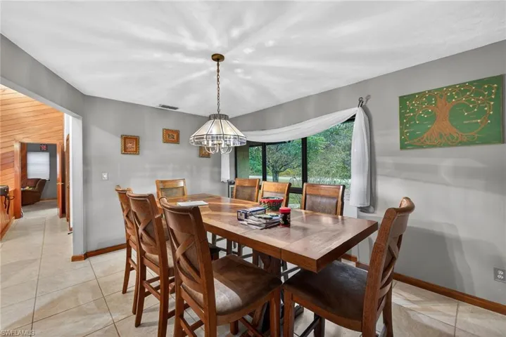 Dining area with suspended lighting and light tile patterned floors
