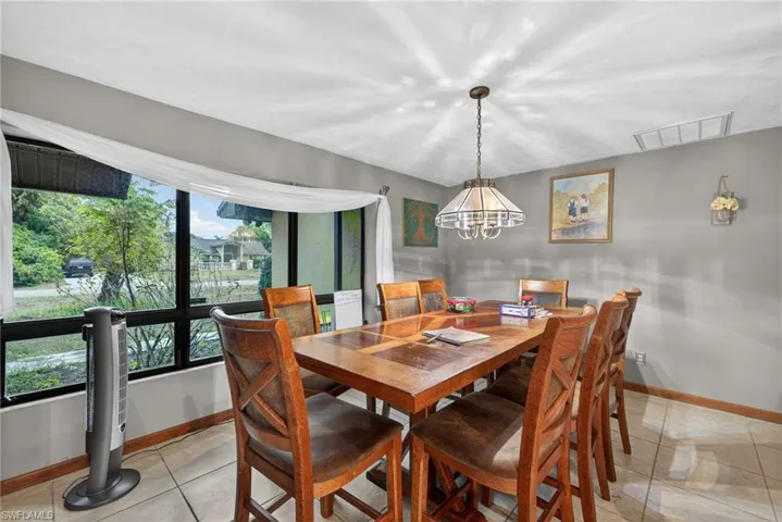Dining room with light tile patterned floors and suspended lighting