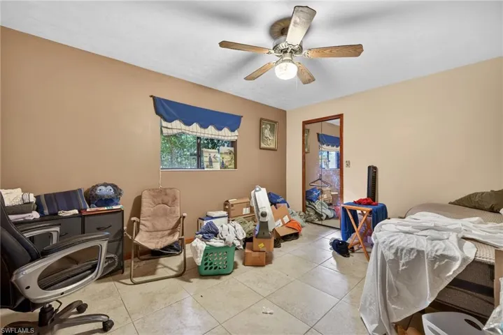 Tiled bedroom with a ceiling fan and a closet