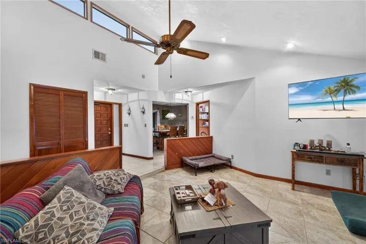 Living area with lofted ceiling and a ceiling fan