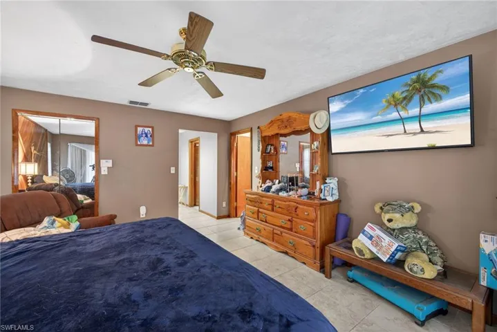 Bedroom with a ceiling fan and light tile patterned flooring