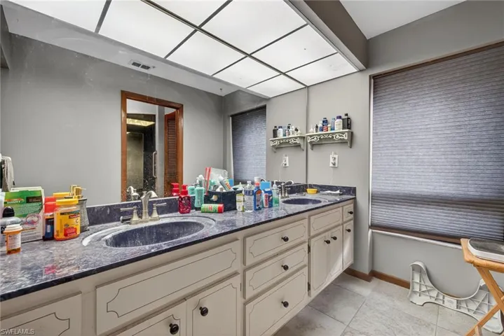 Bathroom with double vanity and light tile patterned floors