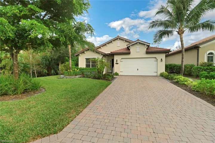 Mediterranean / spanish-style house with a garage and a front lawn