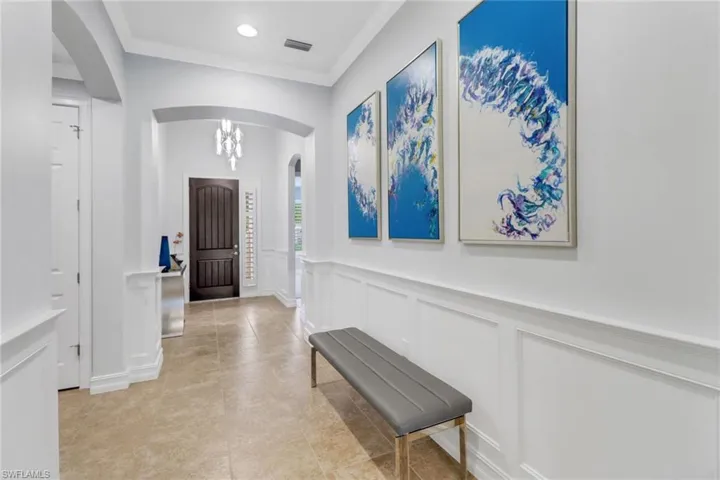 Entryway featuring crown molding and a chandelier