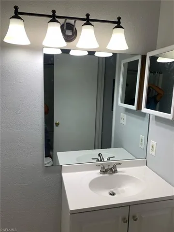 Bathroom featuring vanity and a textured wall