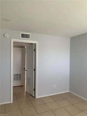 Empty room featuring a textured ceiling and light tile patterned flooring