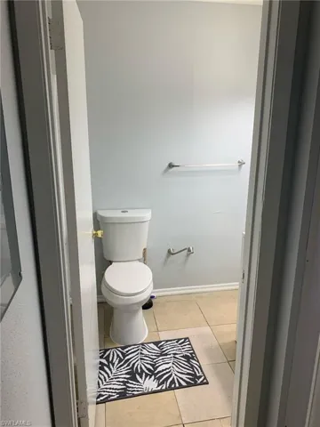 Bathroom with light tile patterned flooring and baseboards