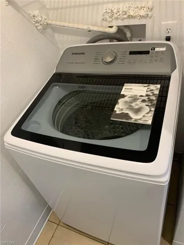 Laundry view of a textured wall and washer / dryer