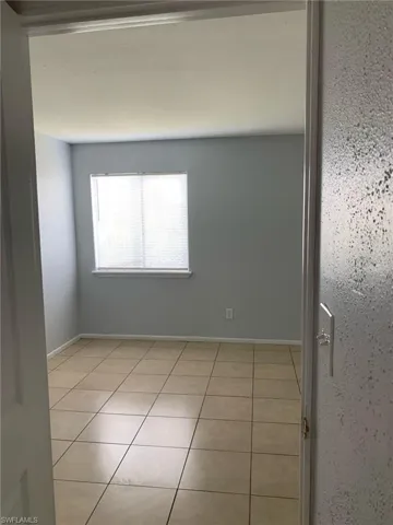 Unfurnished room with light tile patterned floors and baseboards