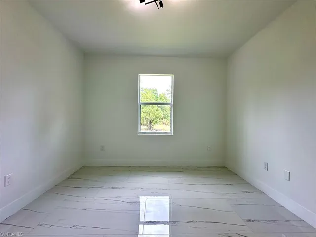 Unfurnished room with light marble finish floors