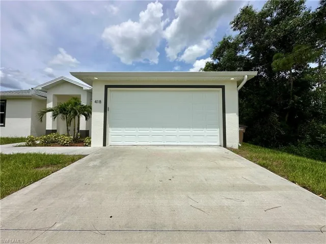 Single story home featuring stucco siding, concrete driveway, and a garage