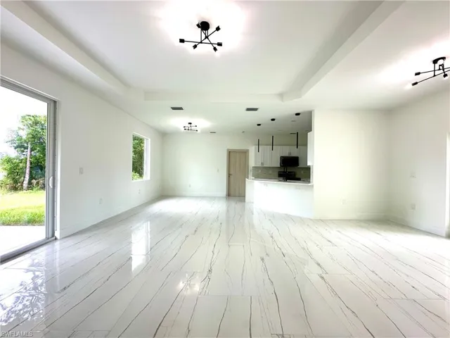Unfurnished living room with a raised ceiling and light wood-style flooring