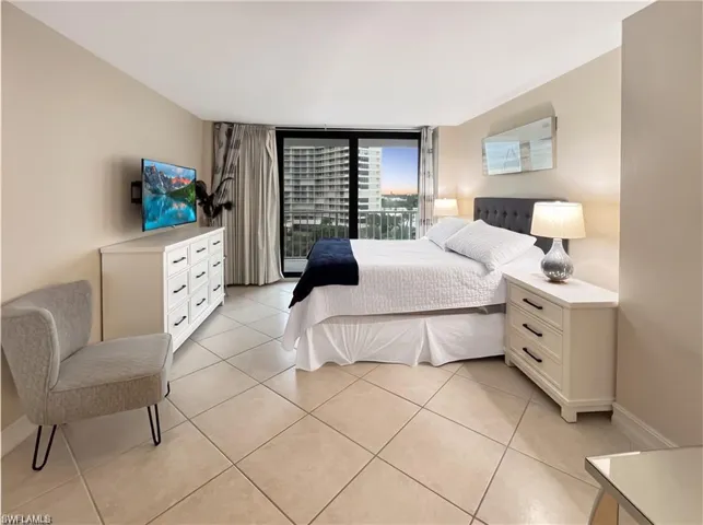 Neutral-toned room featuring large-format diagonal tile flooring and sliding glass doors with direct balcony access
