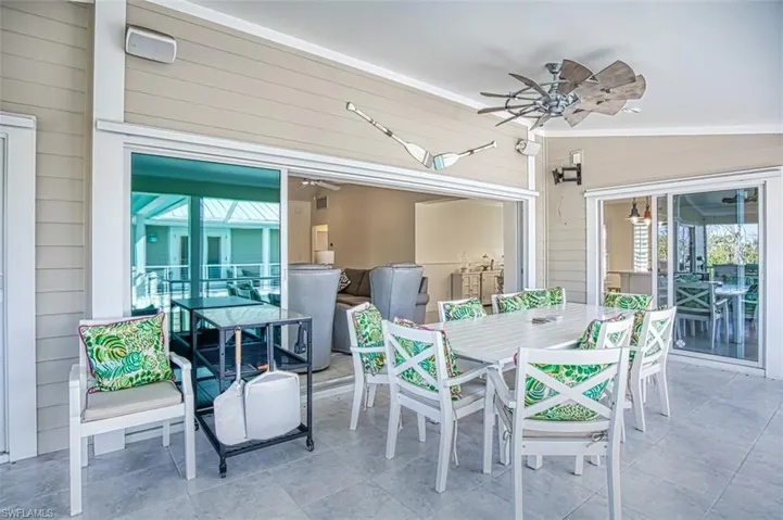 View of patio with outdoor dining area and a ceiling fan
