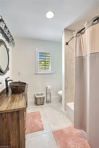 Bathroom featuring vanity and shower / bath combination with curtain
