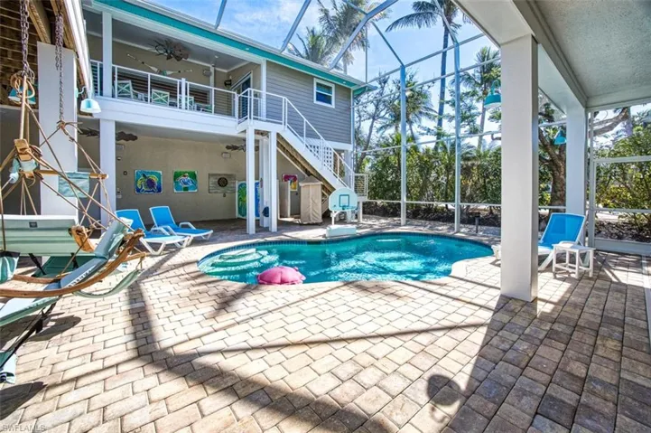 Outdoor pool with a sunroom, glass enclosure, a patio area, and stairway