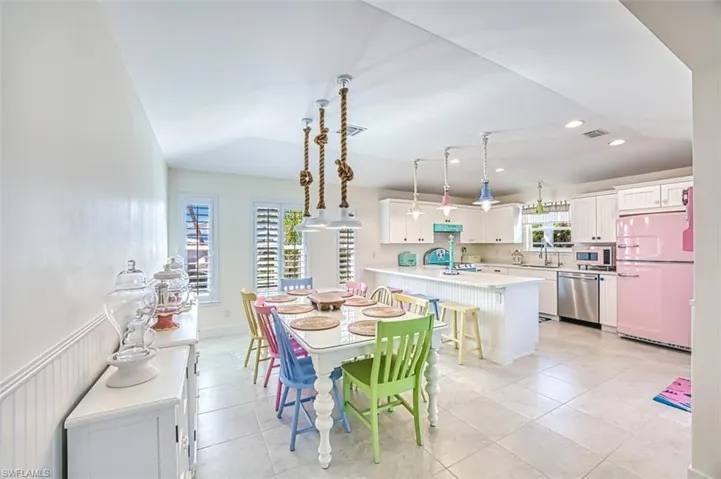 Dining area featuring light tile patterned floors, vaulted ceiling, and recessed lighting
