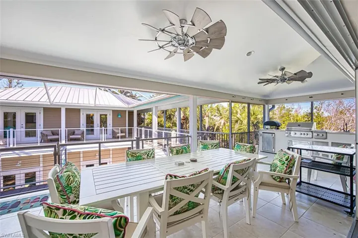 Sunroom featuring a ceiling fan, french doors, exterior kitchen, and healthy amount of natural light