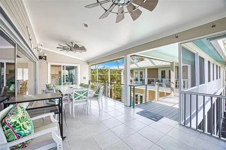 Sunroom featuring a ceiling fan, vaulted ceiling, healthy amount of natural light, and outdoor dining space