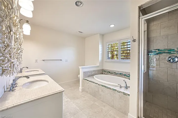 Bathroom with a bath, a stall shower, double vanity, recessed lighting, and light tile patterned floors