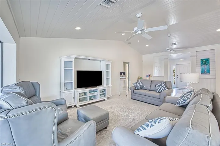 Carpeted living room featuring lofted ceiling, wooden ceiling, and recessed lighting