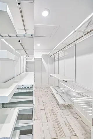 Walk in closet with light wood-type flooring