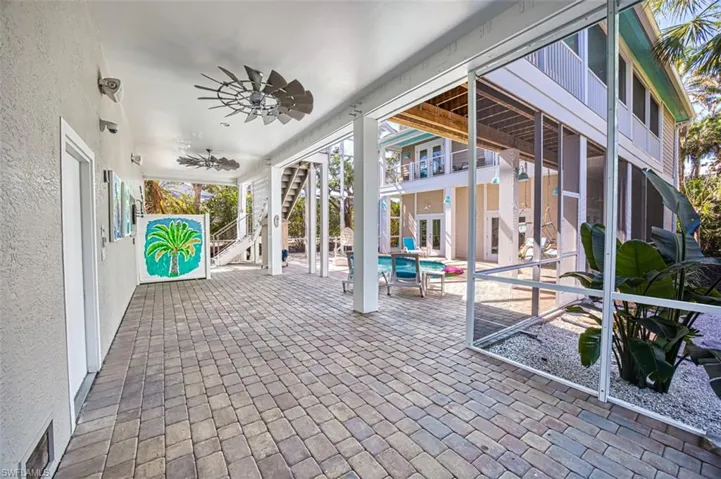 View of patio / terrace featuring stairway, a ceiling fan, and an outdoor pool